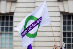 a person with a gender pay equal banner, gender pay gap, equal pay