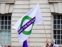 a person with a gender pay equal banner, gender pay gap, equal pay