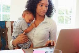 Mother With Baby Working In Office At Home