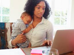 Mother With Baby Working In Office At Home