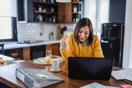 Young business entrepreneur woman working at home while having breakfast, World Productivity Day