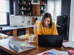 Young business entrepreneur woman working at home while having breakfast, World Productivity Day