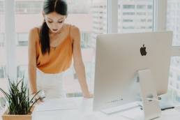 female founder leaning on her desk with computer, private equity, entrepreneur