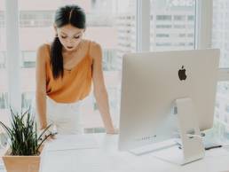 female founder leaning on her desk with computer, private equity, entrepreneur