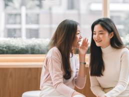 Asian pretty woman chat and gossip someone with her friend in coffee shop, pay rise, secrecy