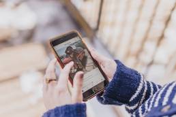 Person holding a phone browsing Instagram, social media