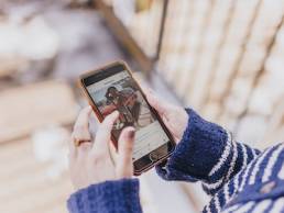 Person holding a phone browsing Instagram, social media
