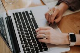 person writing a book on a laptop