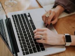 person writing a book on a laptop