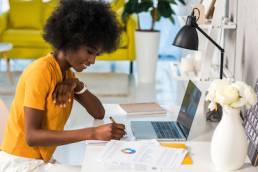 side view of smiling african american female freelancer working at home
