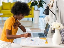 side view of smiling african american female freelancer working at home