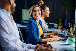 Young woman working in office, smiling with colleagues