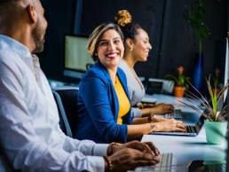 Young woman working in office, smiling with colleagues