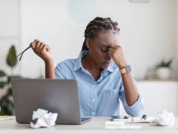 Deadline Stress. Overworked Black Female Entrepreneur Massaging Nosebridge At Workplace In Office, Exhausted After Using Laptop