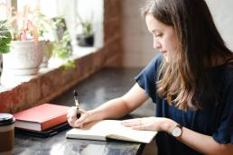 young woman writing in a diary