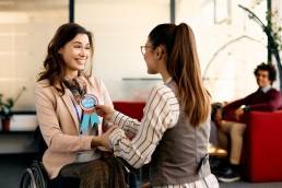 Happy employee receiving employee of the month badge