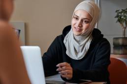 Happy woman wearing hijab smiling during job interview