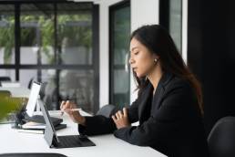 Side view of business working on tablet in modern office setting