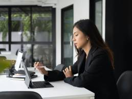 Side view of business working on tablet in modern office setting