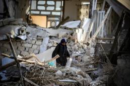 Women walking through rubble after earthquake