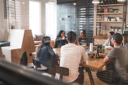 Group of colleagues sittitng at a table having meeting in office