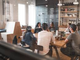 Group of colleagues sittitng at a table having meeting in office