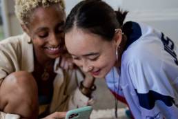 women holding smartphone and smiling, gen z