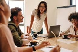 Group of multi ethnic executives discussing during a meeting. Business man and woman sitting around table at office and smiling.