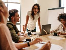 Group of multi ethnic executives discussing during a meeting. Business man and woman sitting around table at office and smiling.