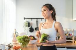 Smiling happy woman making healthy lunch, healthy food, looking after gut