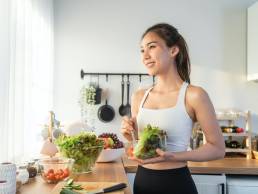 Smiling happy woman making healthy lunch, healthy food, looking after gut