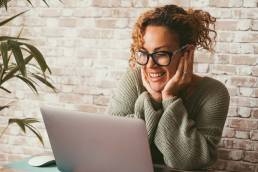Happy woman working from home, using imposter syndrome to her advantage