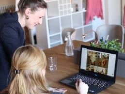 Photograph of two women working on a laptop