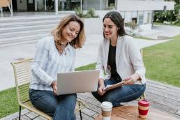 Hybrid working, women sitting at table working outside