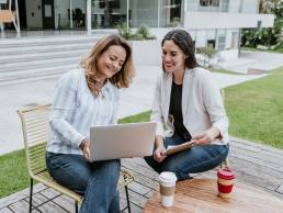 Hybrid working, women sitting at table working outside
