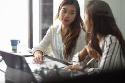 Female leader with colleague, leadership, mentoring, two businesswomen working together